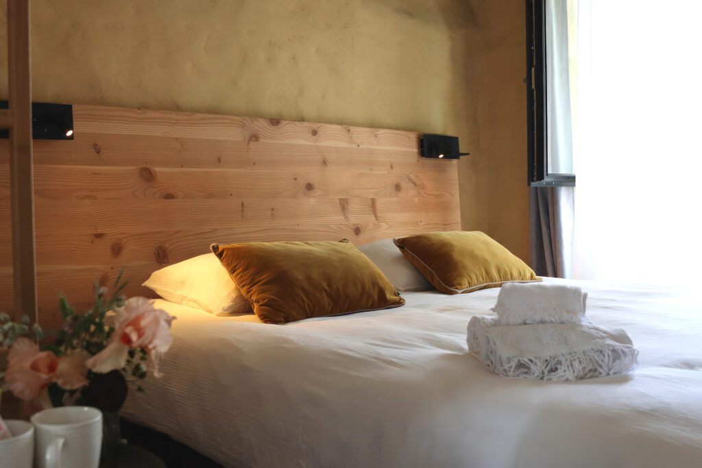 Lit de la chambre Capucine avec coussins jaunes