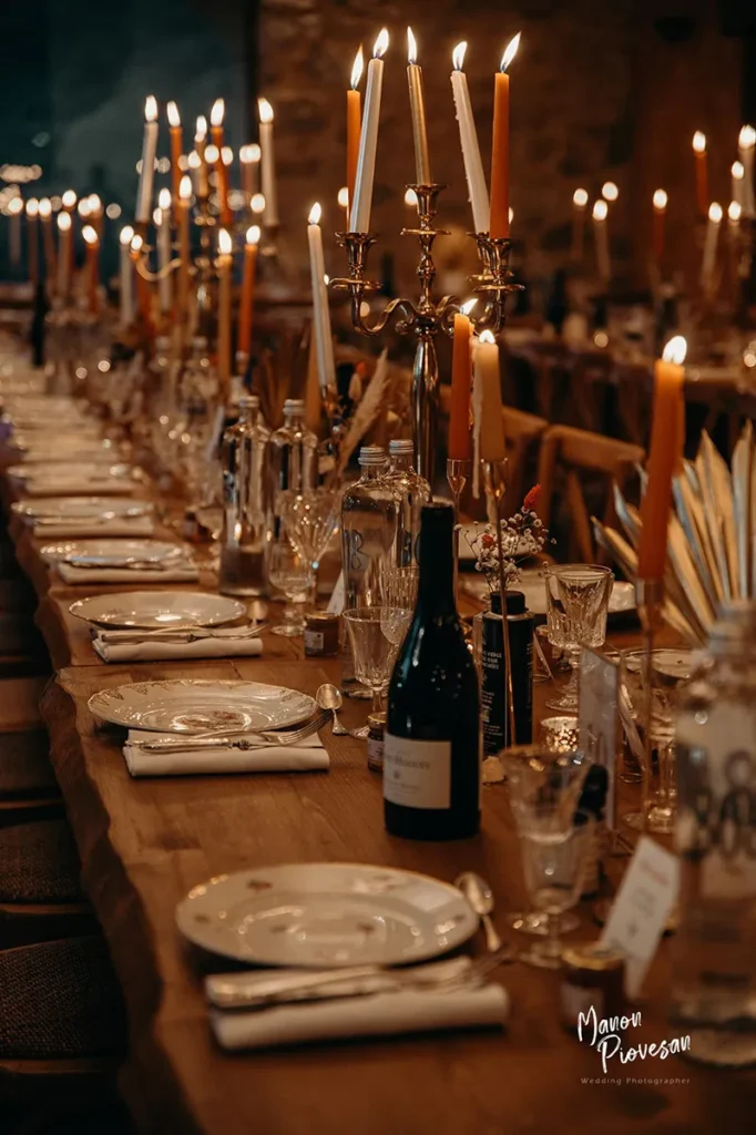 Longue table de banquet dressée aux chandelles pour un mariage