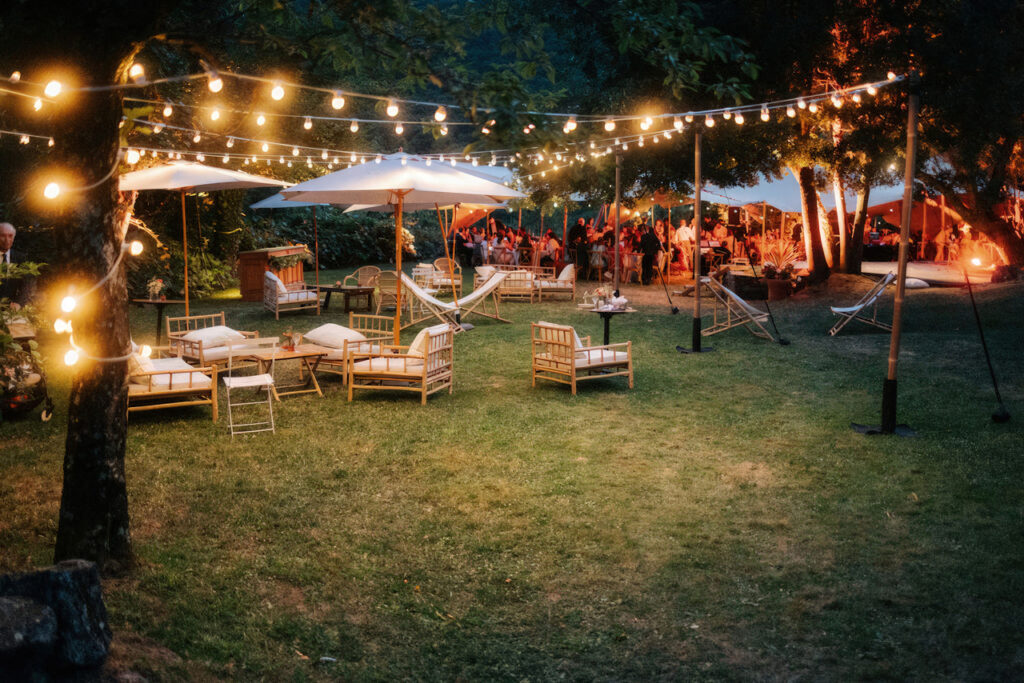 Réception de mariage en plein air sous des guirlandes lumineuses